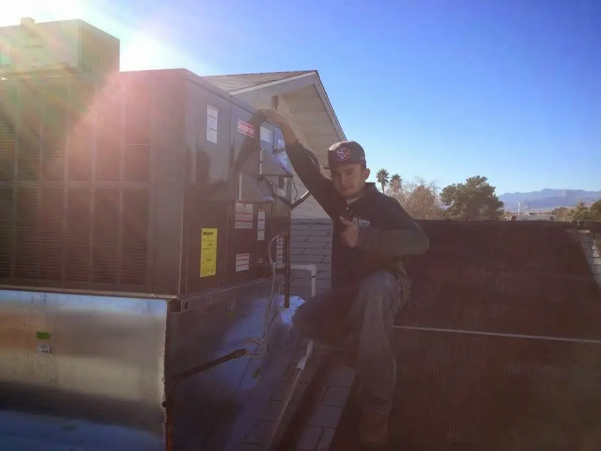 HVAC technician performing HVAC Inspection on a rooftop unit in Guilderland